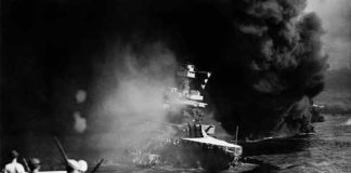 Navy Fire Cluster Aboard Ships Becoming Major Threat A naval ship engulfed in smoke and flames with military personnel observing from a distance