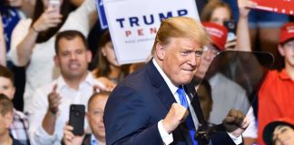 Trump’s Endorsement Delivers Another MAJOR WIN! man in suit raising fists at a rally podium