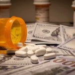 Are Drugs Actually Flowing Out of America Instead of In? Prescription pill bottle and white tablets on scattered US dollar bills