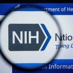 Magnifying glass focuses on NIH logo on a website