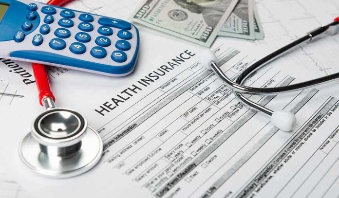 shutterstock_1476657929 Health insurance form with stethoscope, calculator, and cash