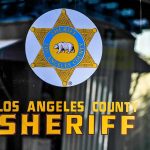 DOJ Hire With 3 DUIs Runs Public Outreach Los Angeles County Sheriff emblem on a glass door