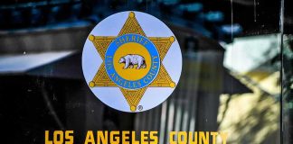 DOJ Hire With 3 DUIs Runs Public Outreach Los Angeles County Sheriff emblem on a glass door