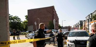 Domestic Call Erupts—Officer Killed Police officers secure an urban street with yellow tape near patrol cars