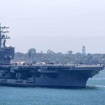 Trump Stuns With Response to USS Lincoln Sailor Crisis Aircraft carrier escorted by a tugboat in a harbor