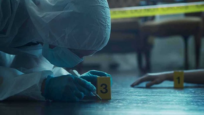 shutterstock_2196208523 forensic investigator in protective suit examining crime scene markers