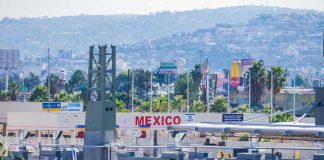 Cartel Attack Whisper Freezes U.S. Ops Border crossing booths at Mexico entry point with cityscape in background