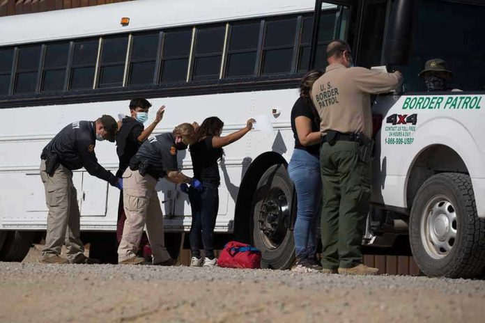 Border patrol officers investigating people near a bus.