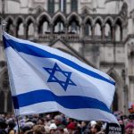 Gunfire Erupts Outside Synagogue Israeli flag at a crowded outdoor event.
