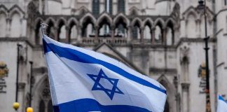 Gunfire Erupts Outside Synagogue Israeli flag at a crowded outdoor event.