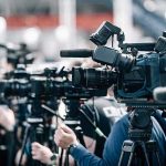 This AI Insider Says the Race Could Kill Us All Broadcast cameras on tripods at a press event
