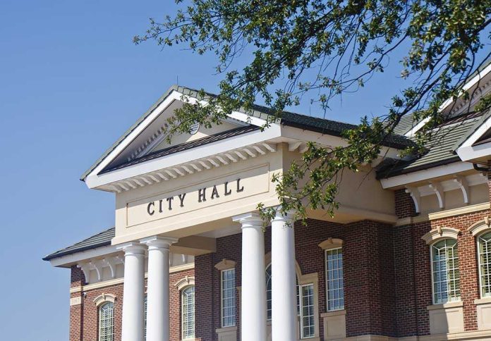 shutterstock_100049108-1 Exterior view of a city hall building with columns and a clear blue sky