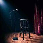 Famous Musician and His Family Murdered in Mexico Microphone on stand beside stool under spotlight on stage