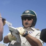 Police officer issues a traffic ticket to a driver