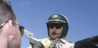 Police officer issues a traffic ticket to a driver