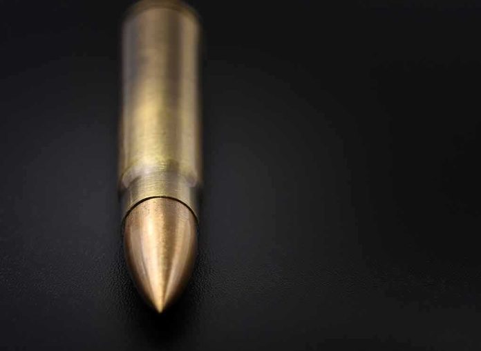 Close-up of a single brass bullet on a dark surface