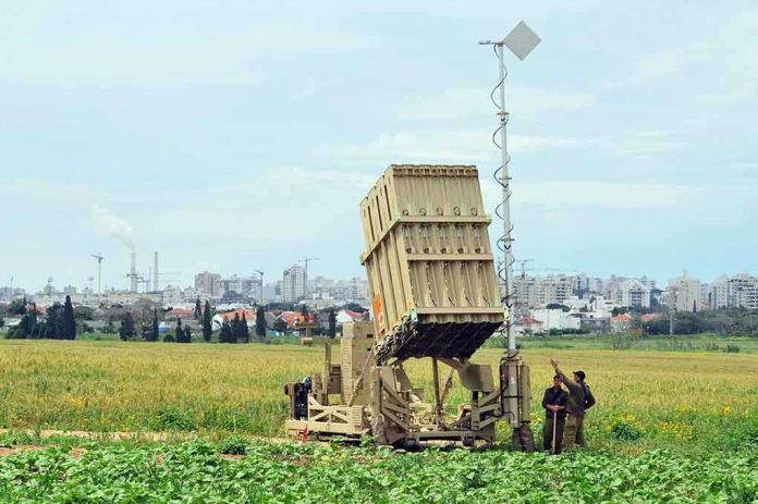 shutterstock_115740022-1 Military defense system deployed in a field with soldiers nearby
