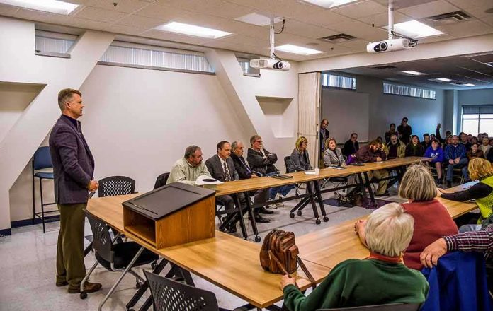 shutterstock_1169519131 Roger Marshall addresses a community meeting with Apostolos Doxiadis among attendees