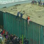 ‘Grandmas in Kayaks’ Help Block Foreigner Invasion People climbing a tall beachside border fence