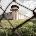 Iran’s Executions Accelerate Under Cover of War and Negotiations Prison watchtower behind chain-link fence