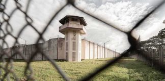 Prison watchtower behind chain-link fence