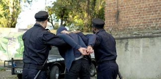 Germany Indicts 7 Hamas Suspects in Europe Terror Plot police officers arresting a person against a wall outdoors