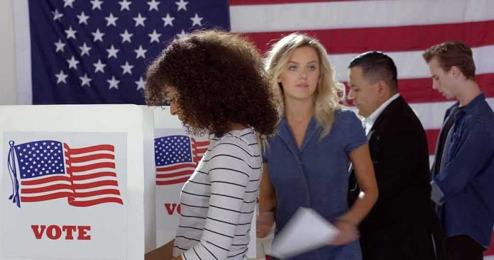 shutterstock_1739643257 Voters at polling booths in front of an American flag