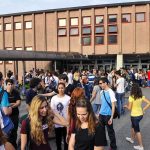 Students gathered outside a school building entrance