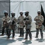 Shocking Lapses Exposed at Trump Rally Line of soldiers in riot gear standing on a city street