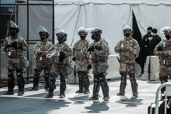shutterstock_1897873573 Line of soldiers in riot gear standing on a city street