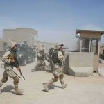 Islamic State Leader Hunted: Ominous Message to Africa Soldiers in desert uniforms run past a checkpoint amid dust