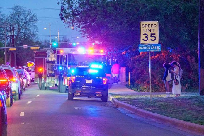shutterstock_1953868816 Emergency vehicles with flashing lights on a city street at night