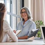 Smiling woman with gray hair talking in a modern office