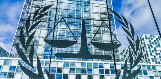 Scales of justice emblem on glass facade of modern office building