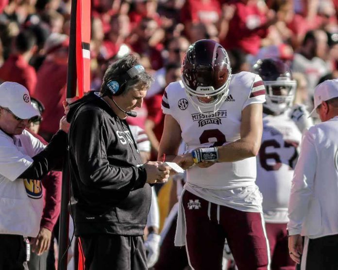 shutterstock_2070833297 football coach and quarterback confer on sideline