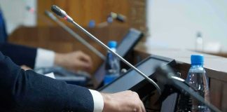 Person pressing a button on a conference microphone panel
