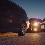 Rising Star Busted—Meth Shocker in Alabama Police officer at patrol car during traffic stop at dusk