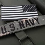 U.S. Navy patch and monochrome American flag patch on green gear