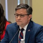 Ethics Warning Hits Fed Nominee Mid-Hearing Man in blue suit with glasses speaking into a microphone