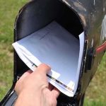 Mail-In Voting Shake-Up Stuns Officials Hand retrieving mail from an open rural mailbox