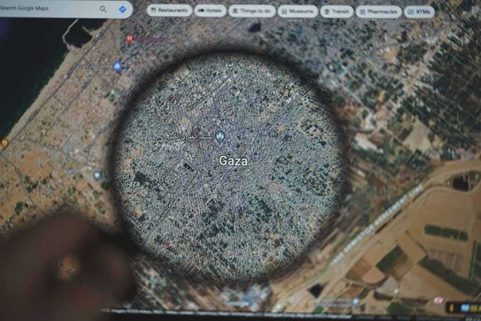 shutterstock_2372300801 Magnifying glass highlighting Gaza on a digital map