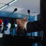 Speaker at podium with multiple microphones
