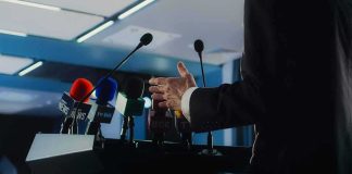 Speaker at podium with multiple microphones