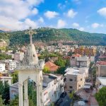 Bell tower with cross overlooking a hillside town