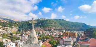 Bell tower with cross overlooking a hillside town