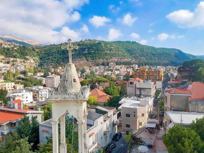 shutterstock_2514304511 Bell tower with cross overlooking a hillside town