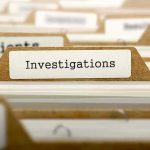File folder tab labeled Investigations in a row of manila folders