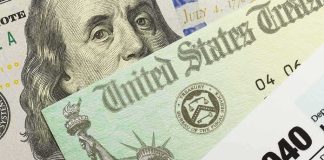 U.S. tax refund check, 1040 form, and hundred-dollar bill