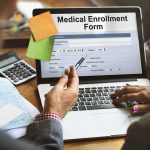 AI Chatbots Are Quietly Running Congress Laptop displaying a medical enrollment form with two people reviewing it