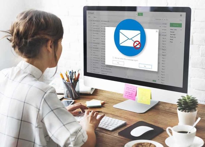 shutterstock_524195053 Woman using desktop computer with email warning popup
